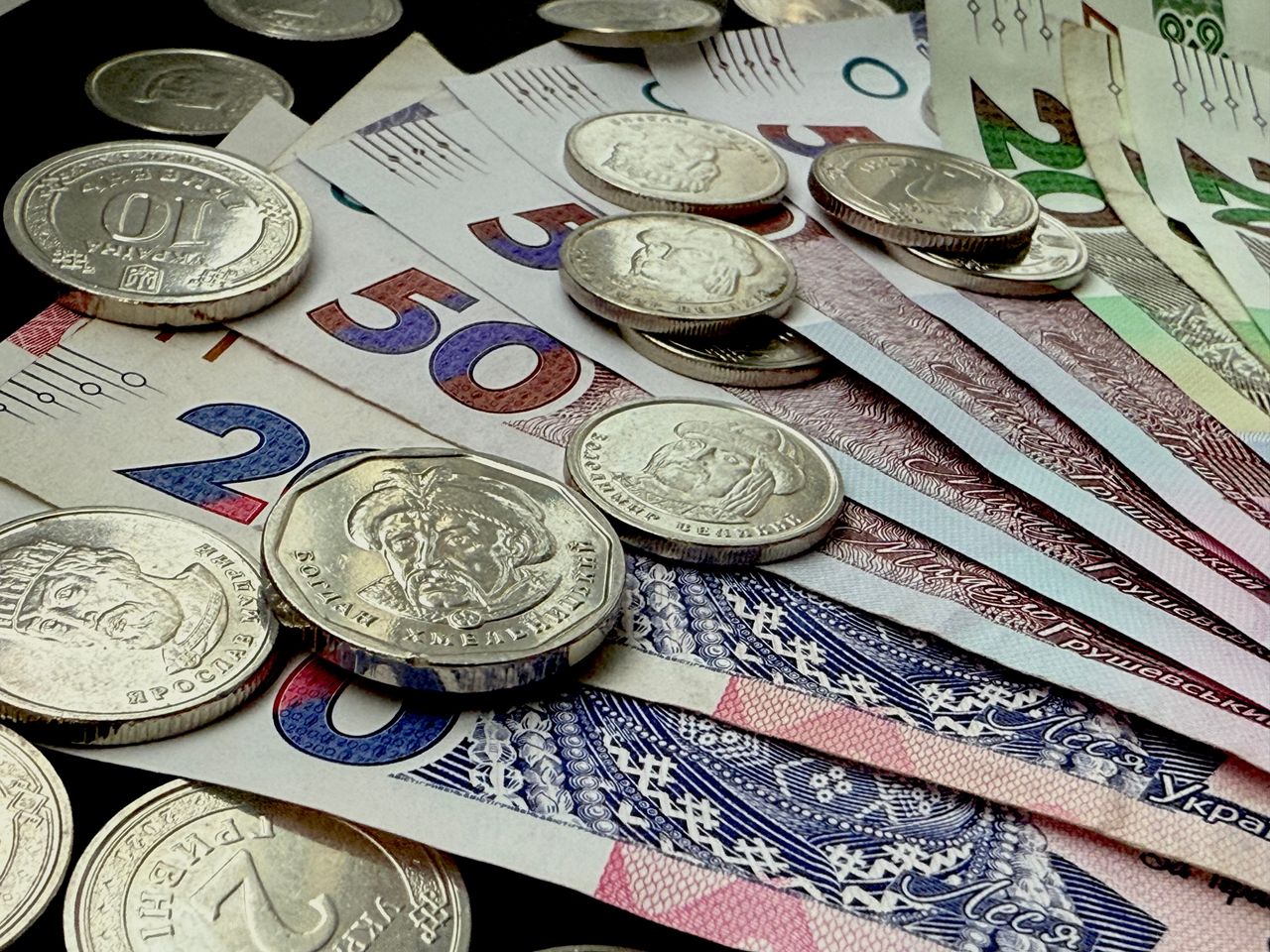 Close-up of various coins and banknotes from different countries, showcasing diversity in currency.